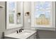 Bright bathroom features a modern sink and countertop with a large mirror and a window at 226 Chastain Preserve Ne Ln, Atlanta, GA 30342