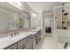 Bright bathroom with double sinks, granite countertops, a large mirror, and a glass-enclosed shower at 226 Chastain Preserve Ne Ln, Atlanta, GA 30342