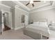 Large bedroom with a bed, bench, tray ceiling, and doorway leading to an en-suite bathroom at 226 Chastain Preserve Ne Ln, Atlanta, GA 30342