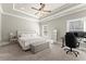 Spacious bedroom featuring a tray ceiling, large bed, sitting bench, and a work desk with two windows at 226 Chastain Preserve Ne Ln, Atlanta, GA 30342