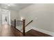 Upstairs hallway with wood floors, iron railing, and a view into a room at the end of the hall at 226 Chastain Preserve Ne Ln, Atlanta, GA 30342