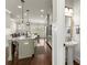 Open kitchen with a large island, modern pendant lighting, and stainless steel appliances next to a half bathroom at 226 Chastain Preserve Ne Ln, Atlanta, GA 30342