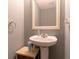 Powder room featuring a pedestal sink, a decorative mirror and neutral color palette at 25 Shadowbrook Ct, Covington, GA 30014