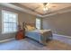 Comfortable bedroom featuring a trey ceiling, a ceiling fan and a large window allowing in plenty of natural light at 25 Shadowbrook Ct, Covington, GA 30014