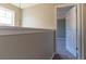 Hallway with neutral colors, adjacent to a carpeted room, and a view to the window at 25 Shadowbrook Ct, Covington, GA 30014