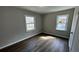 Bright bedroom featuring wood-look flooring, neutral paint, and windows offering natural light at 110 Raymond St, Jonesboro, GA 30236