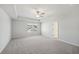 Spacious bedroom featuring tray ceiling, neutral carpet, ceiling fan, and a large window at 11844 Rizvan Pl, Covington, GA 30014