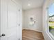 Hallway featuring hardwood floors, a back door, a window, and white walls at 11844 Rizvan Pl, Covington, GA 30014