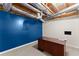 A partially finished basement with a large desk and blue accent wall, perfect for a home office or creative space at 1897 De Winton Pl, Lawrenceville, GA 30043