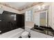 Full bathroom with a unique aesthetic, showcasing a dark tub, vanity, and decorative wallpaper at 1897 De Winton Pl, Lawrenceville, GA 30043