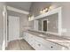 Bathroom featuring double sinks, granite countertops, wood flooring, and white cabinets at 1897 De Winton Pl, Lawrenceville, GA 30043