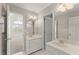 Bathroom featuring double sinks, neutral walls, and an arched window overlooking an additional bedroom at 1897 De Winton Pl, Lawrenceville, GA 30043