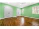 Bright bedroom features a ceiling fan, hardwood floors, and light green walls at 658 Woods Dr, Atlanta, GA 30318