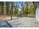 Open wooden deck with metal railing overlooking the lot's level, treed backyard at 658 Woods Dr, Atlanta, GA 30318