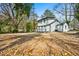 Rear exterior view of a two-story home with a deck and large backyard in need of landscaping at 658 Woods Dr, Atlanta, GA 30318