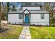 Charming home featuring a new roof, fresh paint, a vibrant blue front door, and a well-manicured lawn at 658 Woods Dr, Atlanta, GA 30318