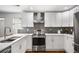 Bright kitchen featuring stainless appliances, white cabinets, gray backsplash and a large island at 658 Woods Dr, Atlanta, GA 30318