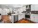 Bright kitchen featuring stainless appliances, white cabinets, gray backsplash and a large island at 658 Woods Dr, Atlanta, GA 30318