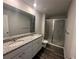 Bathroom with double sink vanity, granite counters, and glass enclosed shower at 8666 Webb Rd, Riverdale, GA 30274