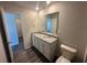 Bathroom with double sink vanity, granite counters, and open doorway at 8666 Webb Rd, Riverdale, GA 30274