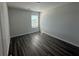 Bedroom with gray walls, gray wood floors, and a window letting in natural light at 8666 Webb Rd, Riverdale, GA 30274