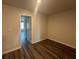 Bedroom with gray walls, gray wood floors, and an open doorway at 8666 Webb Rd, Riverdale, GA 30274