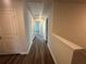 Hallway with neutral paint, gray wood floors, and access to bedrooms at 8666 Webb Rd, Riverdale, GA 30274