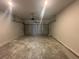 View of empty two car garage with concrete floors, overhead lighting, and a white metal garage door at 8668 Webb Rd, Riverdale, GA 30274