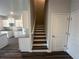 View of staircase from the living room with kitchen in the background at 8668 Webb Rd, Riverdale, GA 30274