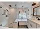 Bright bathroom featuring a soaking tub, glass enclosed shower, and modern fixtures at 245 Davenham Ct, Alpharetta, GA 30005