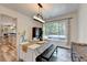 Well-lit dining room featuring backyard view, rustic wooden table, and seamlessly connected to a modern kitchen at 245 Davenham Ct, Alpharetta, GA 30005