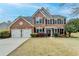 Charming brick home with a well-manicured lawn and a two-car garage, showcasing classic suburban living at 245 Davenham Ct, Alpharetta, GA 30005