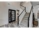 Elegant foyer boasts a staircase with dark wood and white balusters, plus attractive flooring at 245 Davenham Ct, Alpharetta, GA 30005