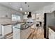 Modern kitchen features marble backsplash, a center island with black countertop, and stainless steel appliances at 245 Davenham Ct, Alpharetta, GA 30005