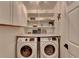 Bright laundry room featuring front loading machines, white cabinetry, and organized shelving at 245 Davenham Ct, Alpharetta, GA 30005