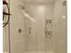 Close up of a glass enclosed shower with white tiled walls and built in shelves at 245 Davenham Ct, Alpharetta, GA 30005