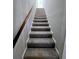 A carpeted staircase featuring a wooden handrail ascends to the upper level, offering a smooth transition between floors at 2870 Pebblebrook Ct, Buford, GA 30518