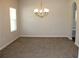 Formal dining room with neutral walls and carpeting complemented by a modern chandelier at 83 Nyishol Way, Dallas, GA 30157