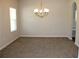 Spacious dining room with neutral carpeting, large window, and stylish chandelier, great for entertaining guests at 83 Nyishol Way, Dallas, GA 30157