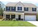 Charming two-story home with a welcoming front porch, attached garage, and well-maintained lawn at 83 Nyishol Way, Dallas, GA 30157