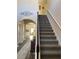 View of a carpeted staircase with white banister and dark wood trim, leading to the upper level at 83 Nyishol Way, Dallas, GA 30157