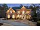 Elegant brick home boasts manicured landscaping, arched windows and stately presence with a circular driveway at 2250 Blackheath Trce, Alpharetta, GA 30005