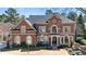 Classic red brick two-story home with manicured landscaping, arched windows, and covered entry at 2250 Blackheath Trce, Alpharetta, GA 30005