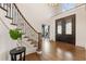 Foyer featuring hardwood flooring, a curved staircase with iron railings, and large double doors at 2250 Blackheath Trce, Alpharetta, GA 30005