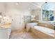 Luxurious bathroom with soaking tub, glass shower, double vanity, and shuttered window at 2250 Blackheath Trce, Alpharetta, GA 30005