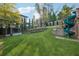 Spacious backyard features green lawn, mature trees, rock feature, and fun playground slide at 4333 Rickenbacker Ne Way, Atlanta, GA 30342