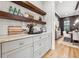 Butler's pantry featuring decorative shelves, stone countertops, custom gray cabinets and view to dining area at 4333 Rickenbacker Ne Way, Atlanta, GA 30342