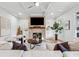 Cozy living room featuring a brick fireplace, hardwood floors, neutral decor, and abundant natural light at 4333 Rickenbacker Ne Way, Atlanta, GA 30342