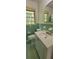 Retro bathroom featuring mint green tile, a white vanity, and vintage fixtures creating a unique aesthetic at 4643 Wesley Dr, Austell, GA 30106