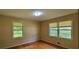 Well-lit bedroom with gleaming hardwood floors and two large windows that let in plenty of natural light at 4643 Wesley Dr, Austell, GA 30106